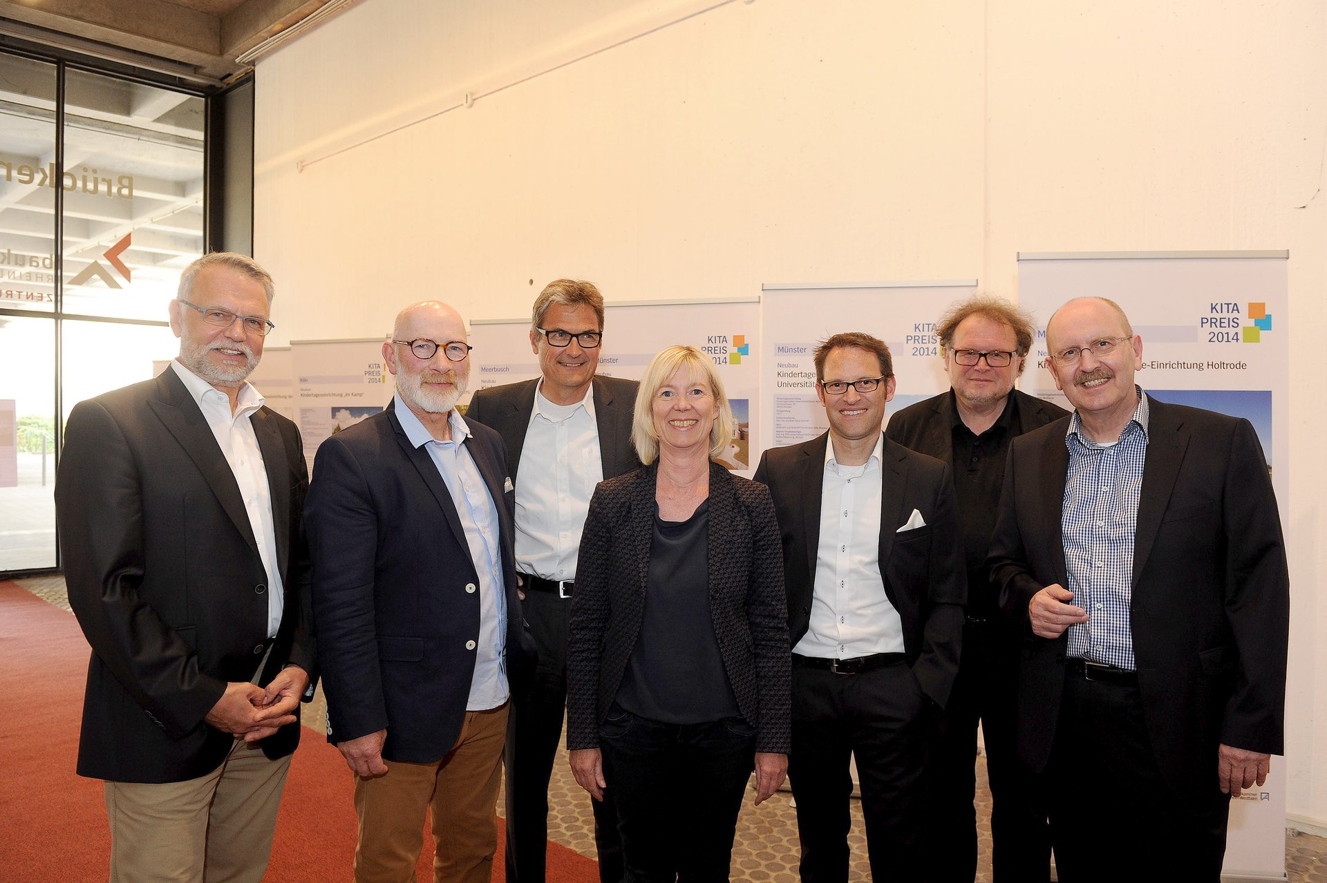 Sieben Personen stehen nebeneinader und blicken lächelnd in die kamera, in der Mitte steht Finanzministerin Doris Ahnen. Im Hintergrund ist die Ausstellung des Kitapreises NRW 2014 zu sehen. Sieben Personen stehen nebeneinader und blicken lächelnd in die kamera, in der Mitte steht Finanzministerin Doris Ahnen. Im Hintergrund ist die Ausstellung des Kitapreises NRW 2014 zu sehen.