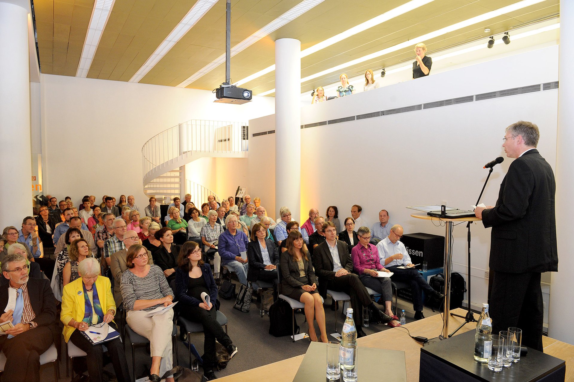 Redner am Pult, aufgenommen im seitlichen Halbprofil, vor sitzendem Publikum, aufgenommen im Vortragsraum des Brückenturms Mainz. (Foto: Kristina Schäfer)